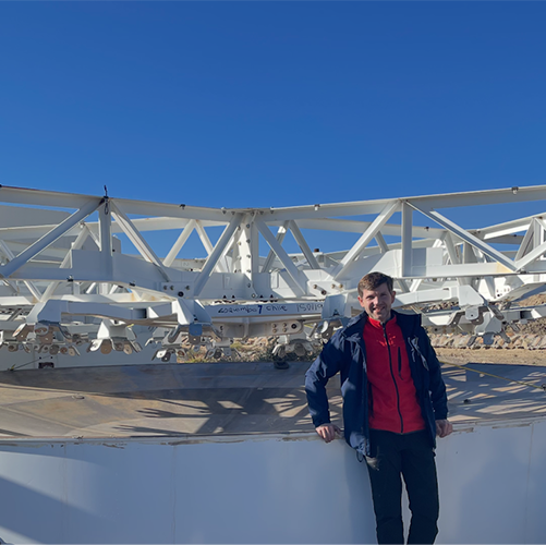 Chris Suberlak next to the M1/M3 surrogate on a clear, sunny day.